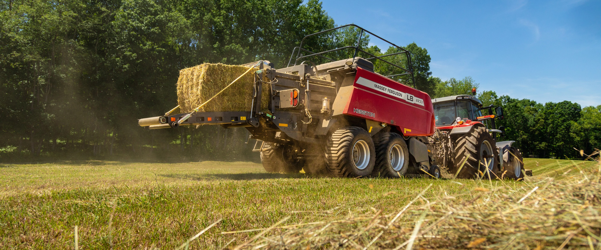 Massey Ferguson baler emptying a twine-wrapped bale.